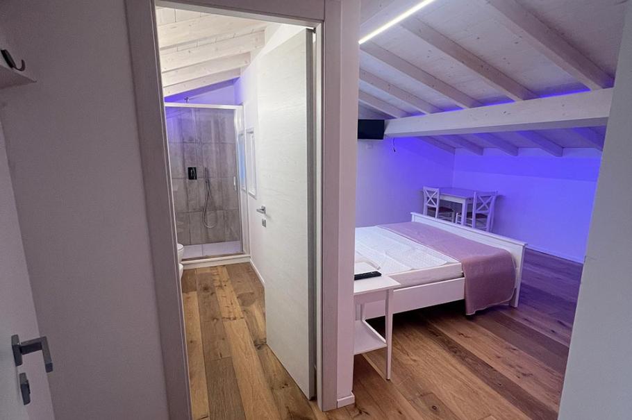 Camera moderna con soffitto in legno, illuminazione LED e pavimento in parquet.